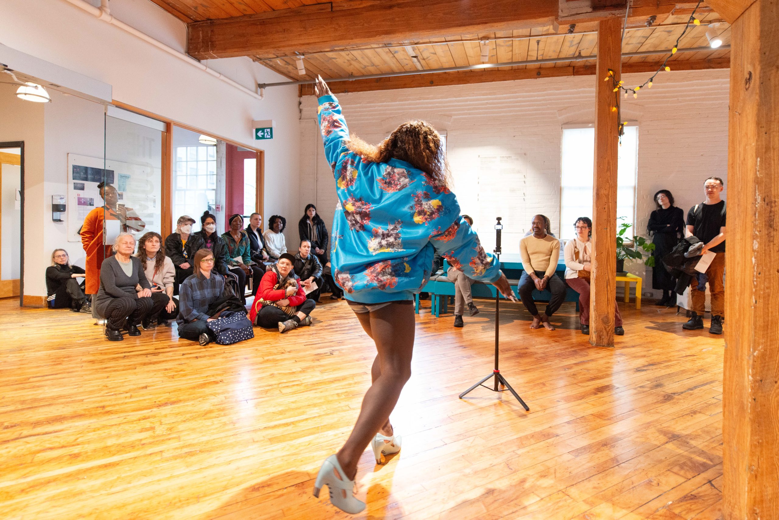 A dancer moves in front of an audience